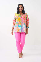 women wearing  a patterned shirt and pink pants on a white background