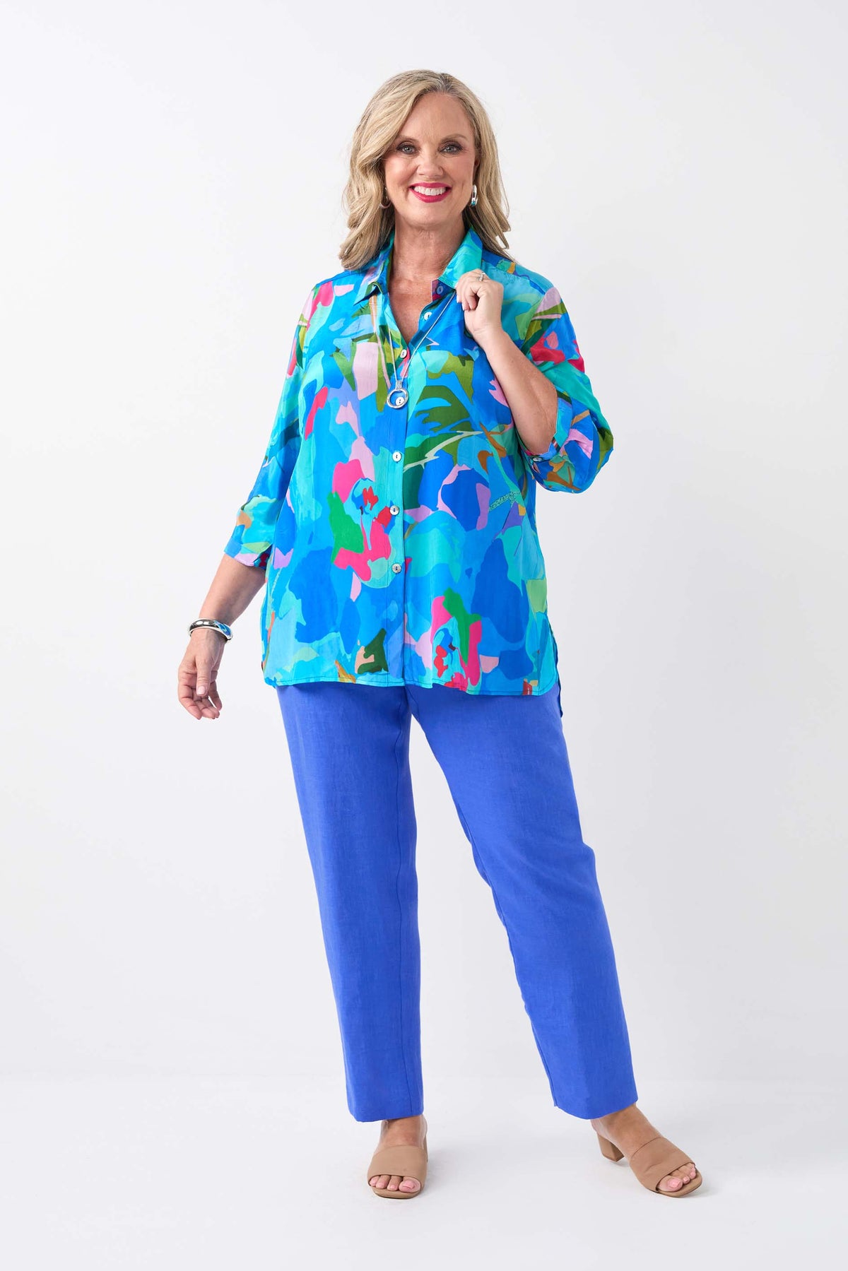 women wearing a blue patterned shirt with blue pants on a white background