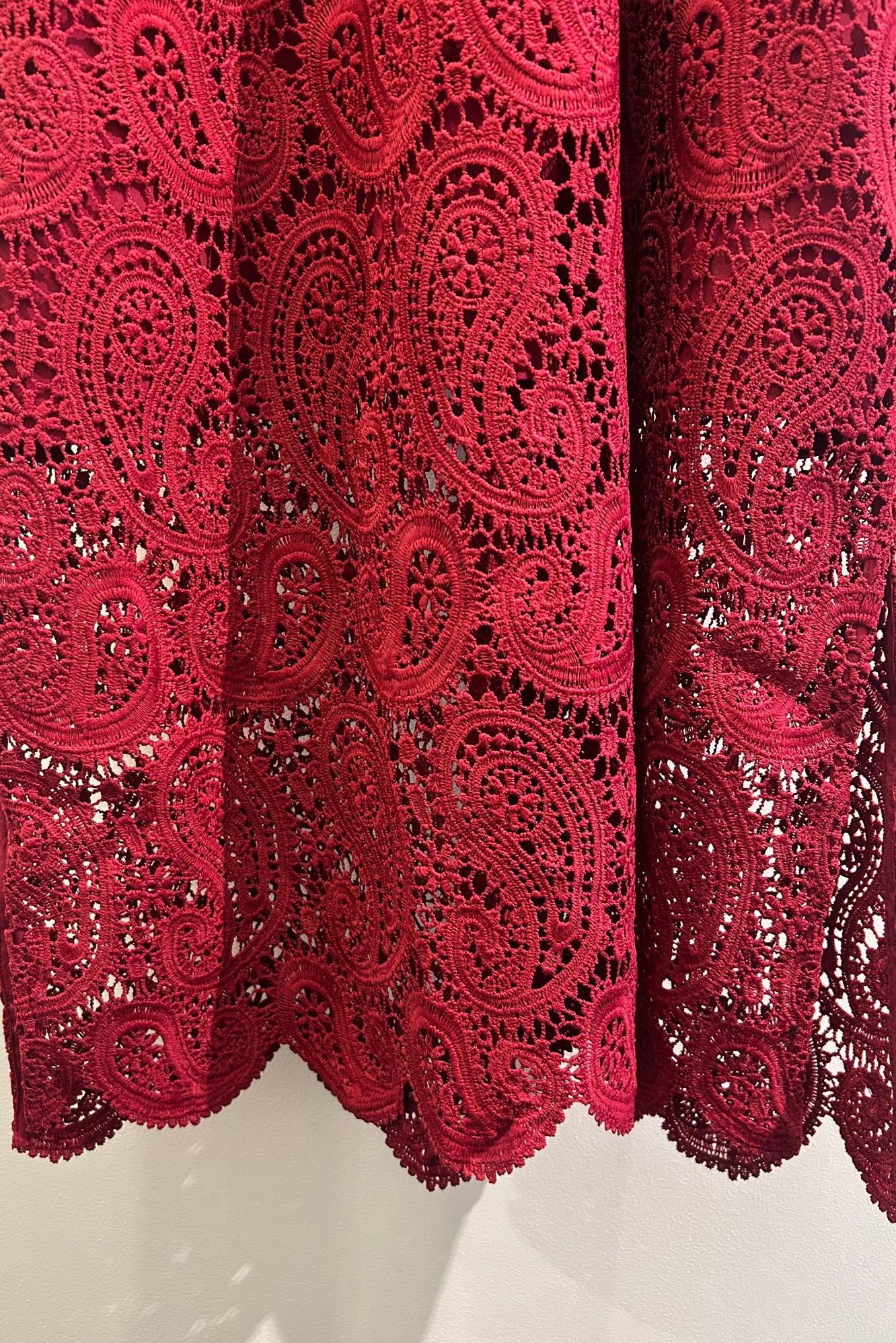 Stack of red lace fabric on a white background