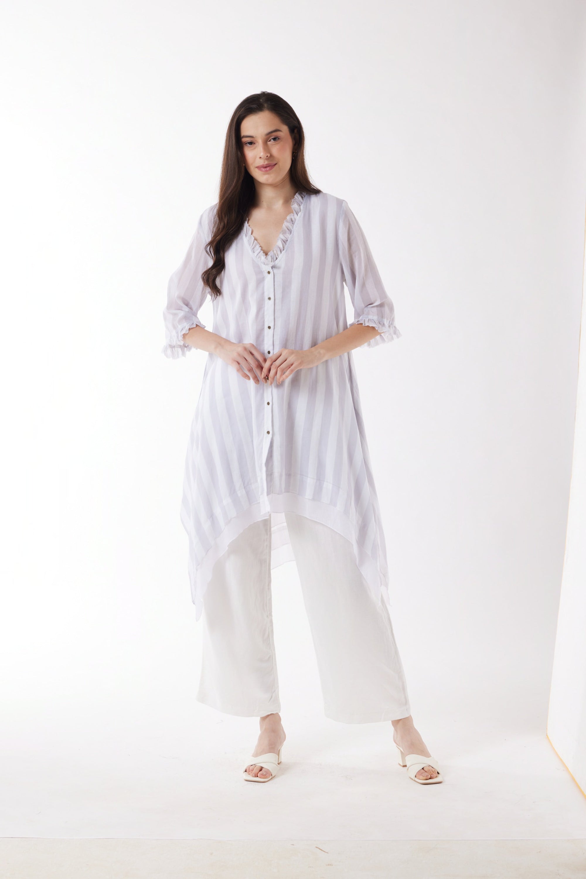 longline white grey stripe shirt and white pants worn by model 