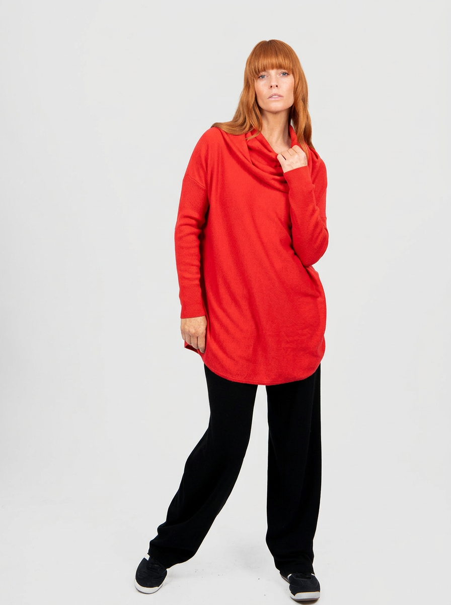Person wearing a red long-sleeve top and black pants on a white background
