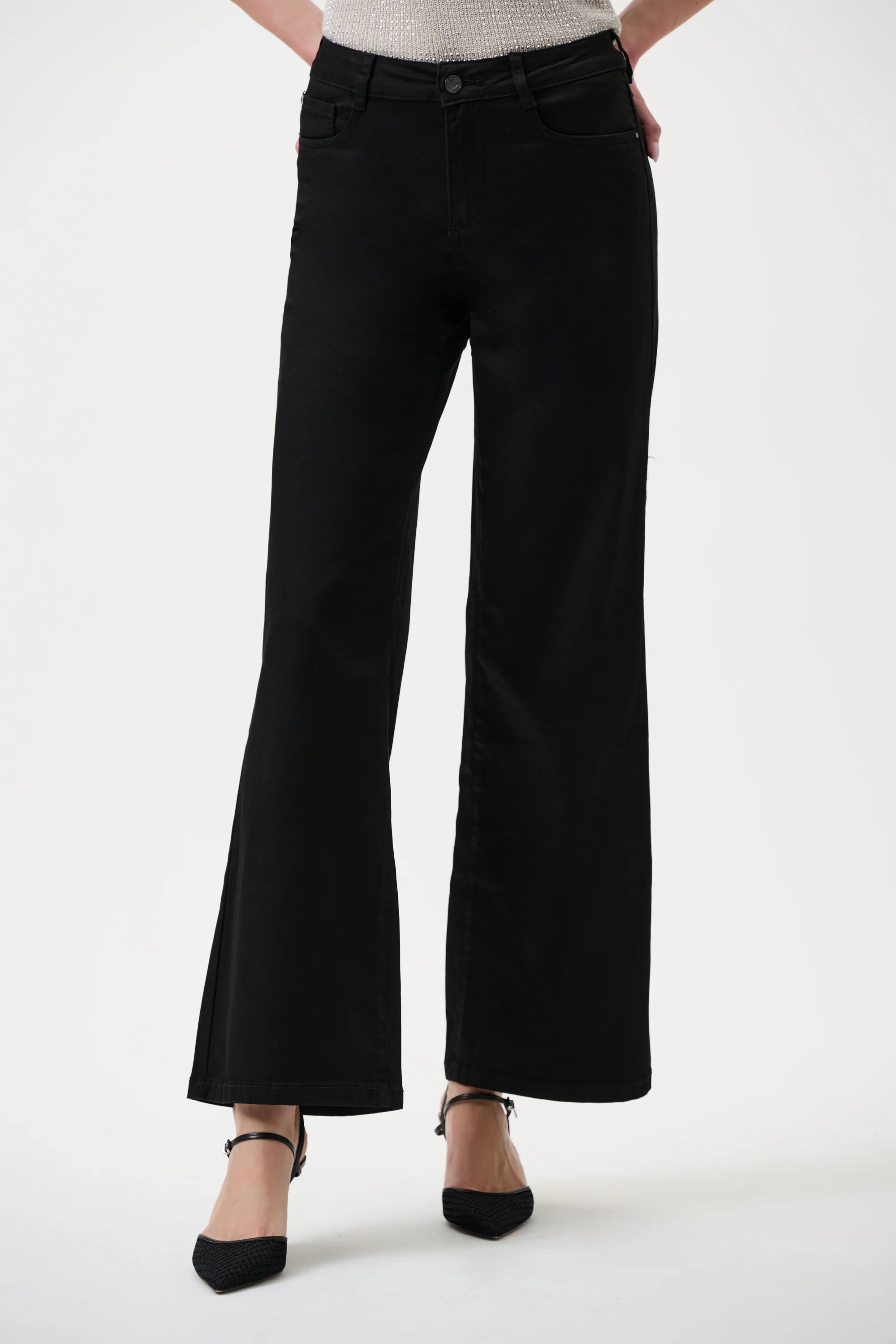 Black wide jeans worn by a person on a white background