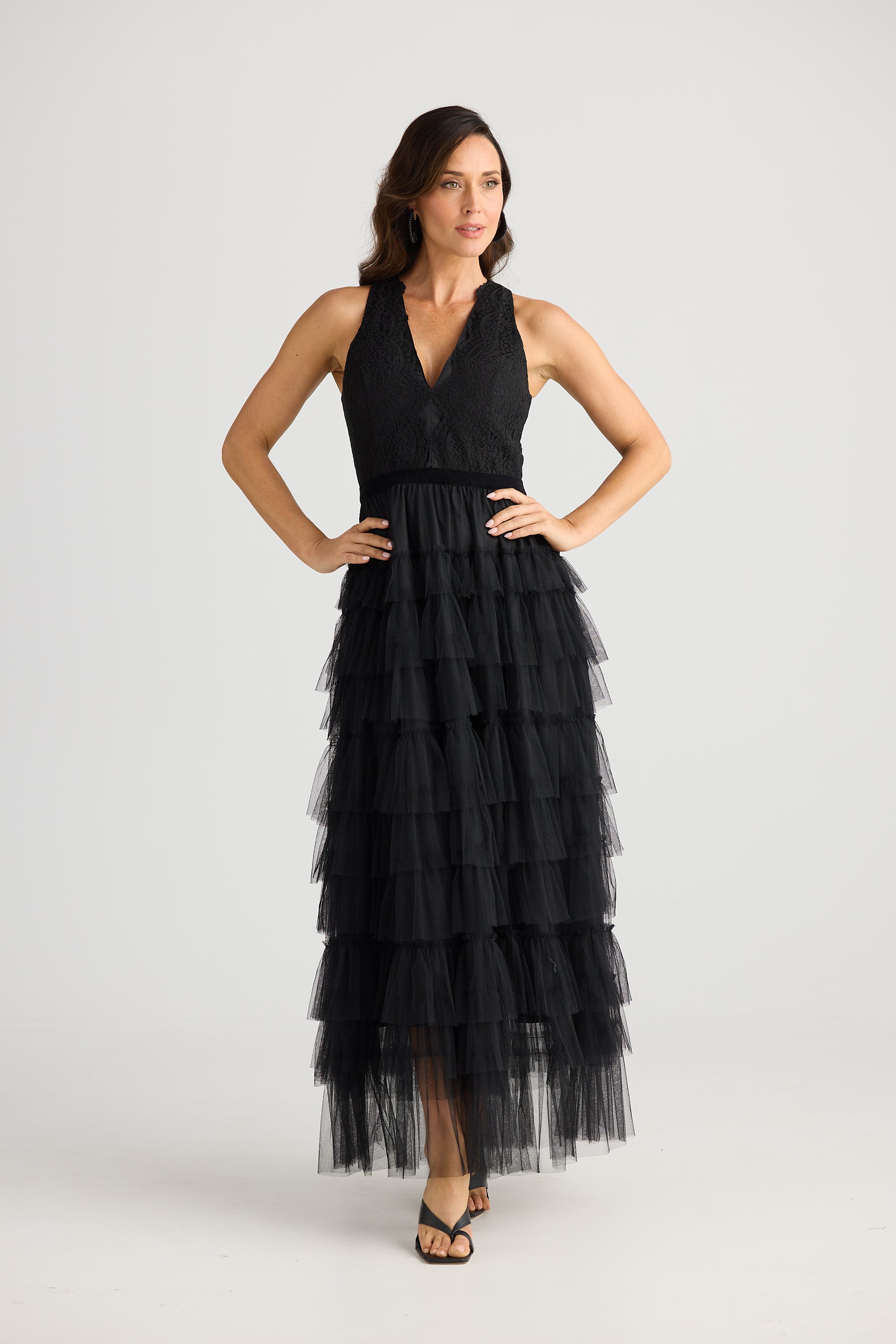 Woman wearing a black tiered dress on a white background