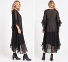 A woman modeling a black sheer midi dress with layered ruffle sleeves and a flowing skirt, paired with black ankle boots, against a clean white studio background.