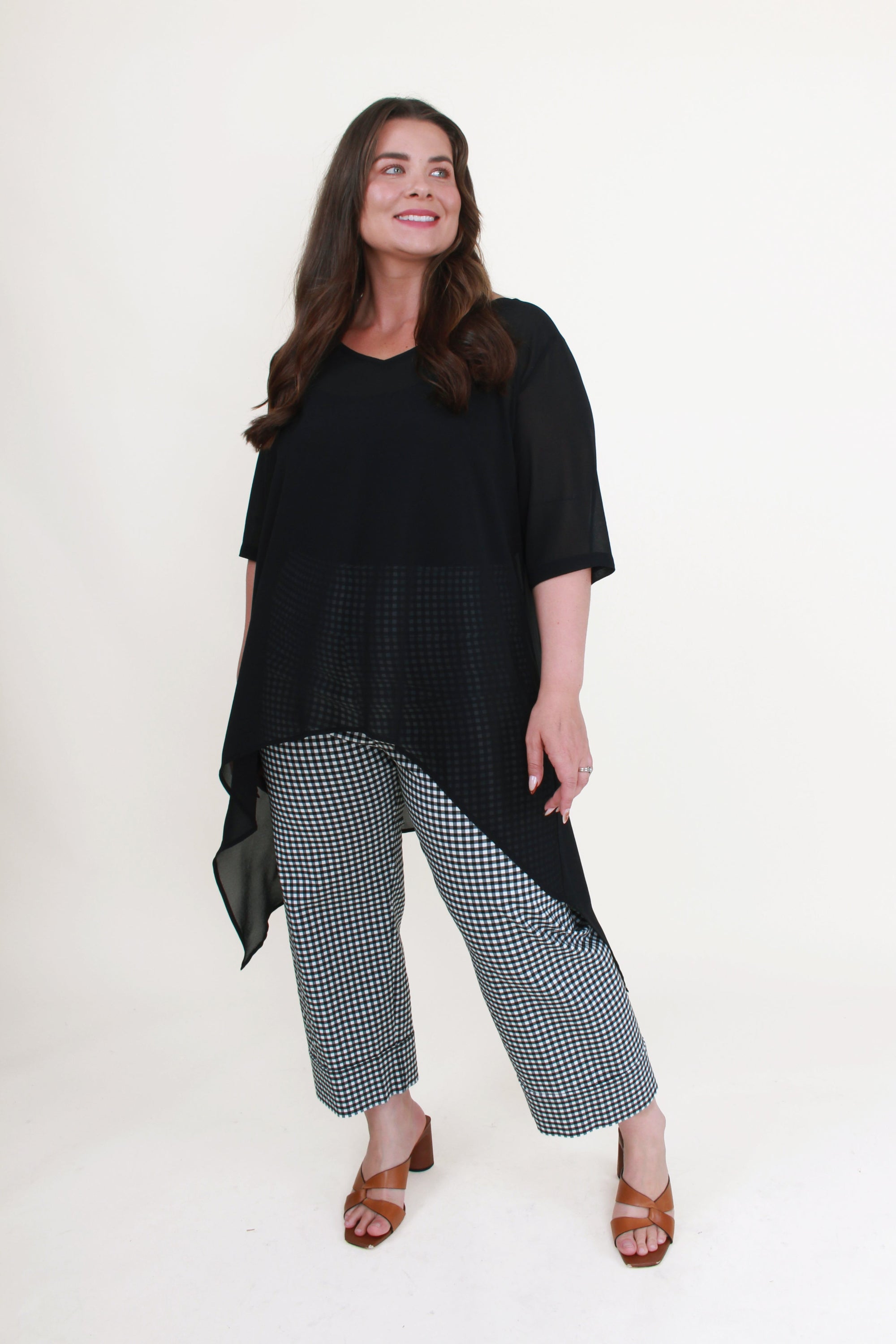 longline black chiffon top and black and white check pants worn by model