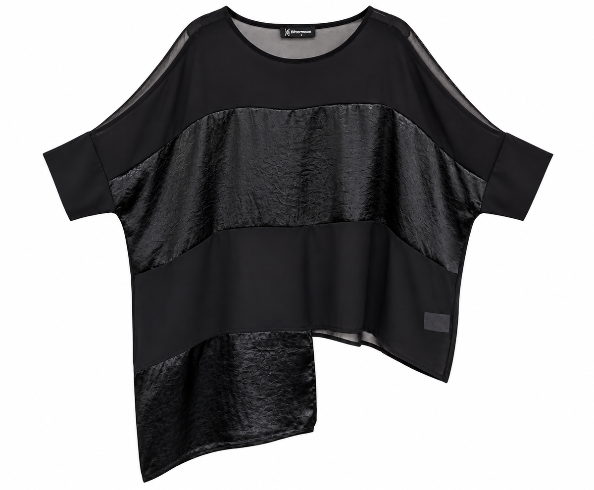 A black asymmetrical blouse with short sleeves, featuring a mix of sheer mesh and textured metallic fabric panels, shown on a plain white background.