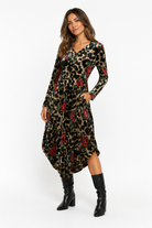 Woman wearing a leopard print dress with red floral patterns on a white background