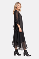 Lady in flowy black dress against a white background