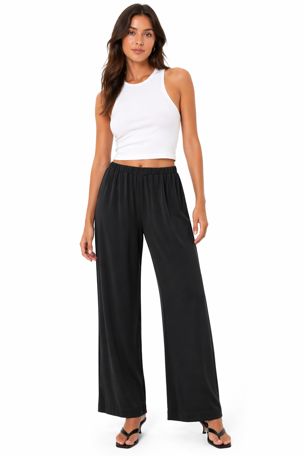 Woman wearing a white sleeveless top and black wide-leg pants on a white background