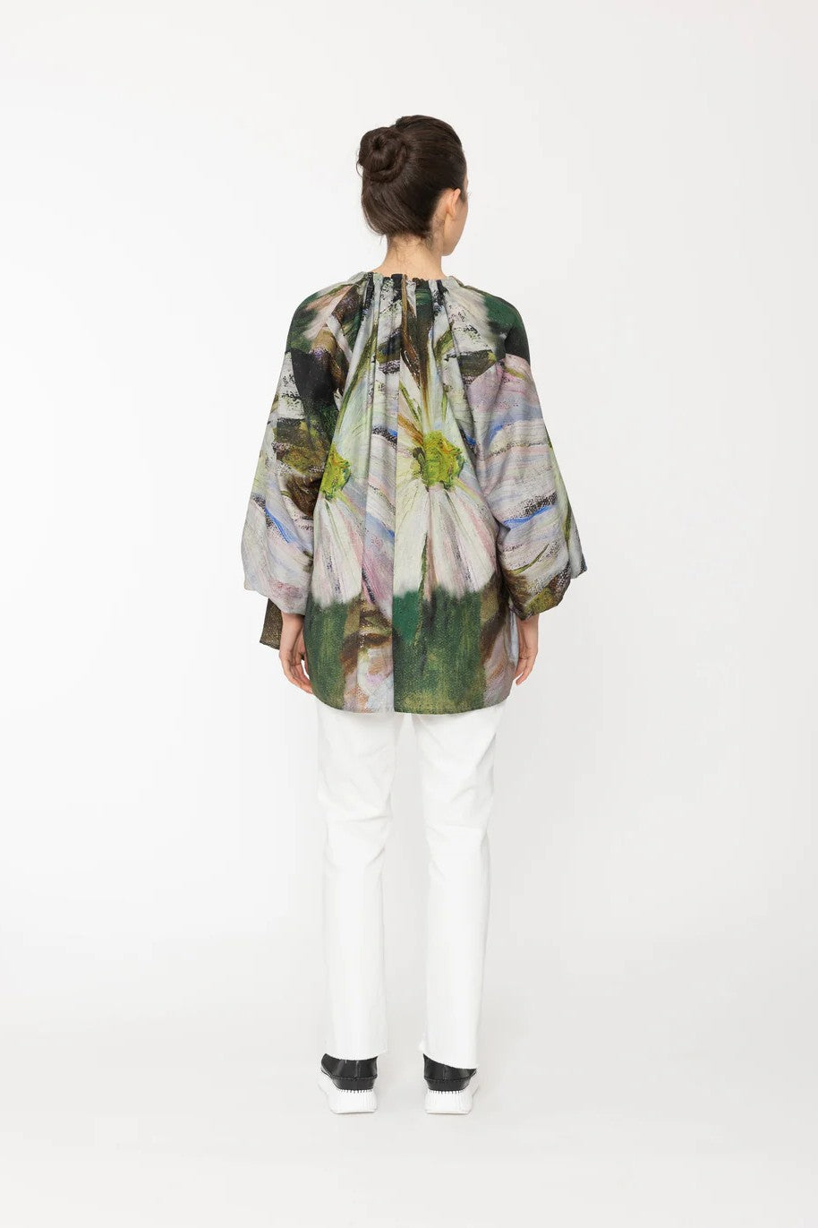 Person wearing a colorful floral kimono-style garment on a white background back angle