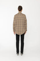 Person wearing a plaid jacket and black pants on a white background back angle