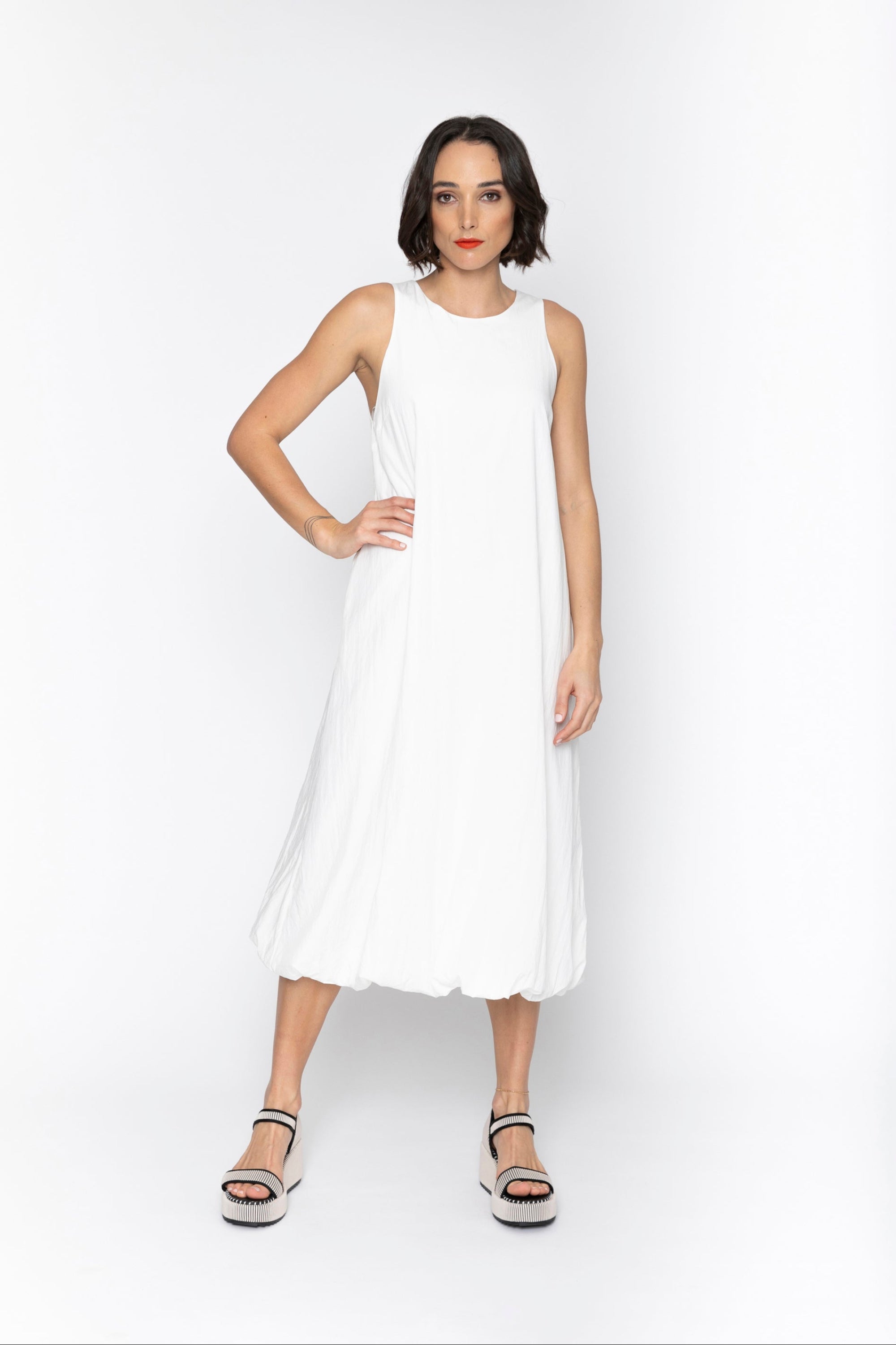 Woman wearing a white sleeveless dress on a white background