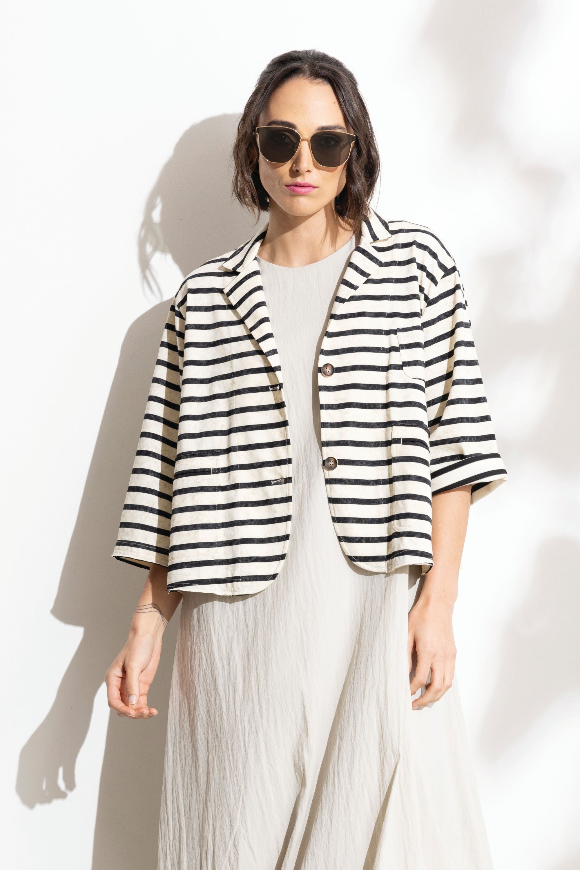 Woman wearing a black and white striped jacket on a white background