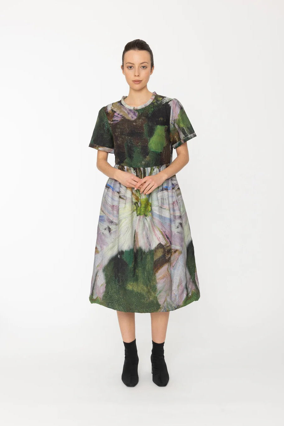 Model wearing a colorful dress with abstract patterns on a white background