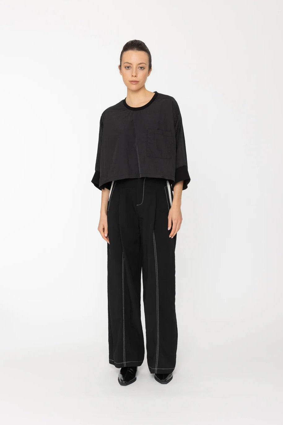 Person wearing a black outfit on a white background