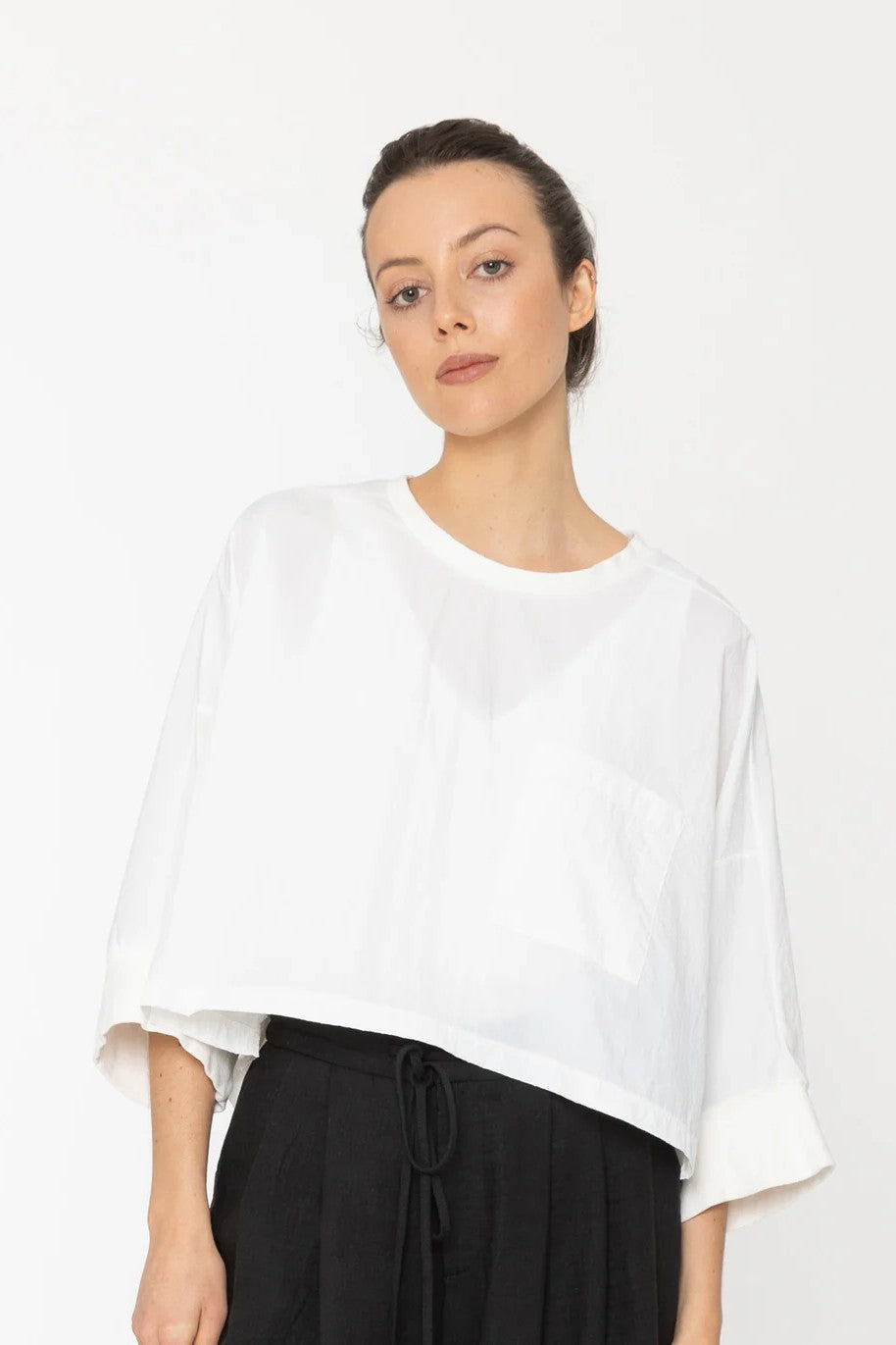 Woman wearing a white blouse and black pants on a white background