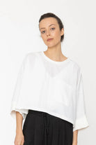 Woman wearing a white blouse and black pants on a white background