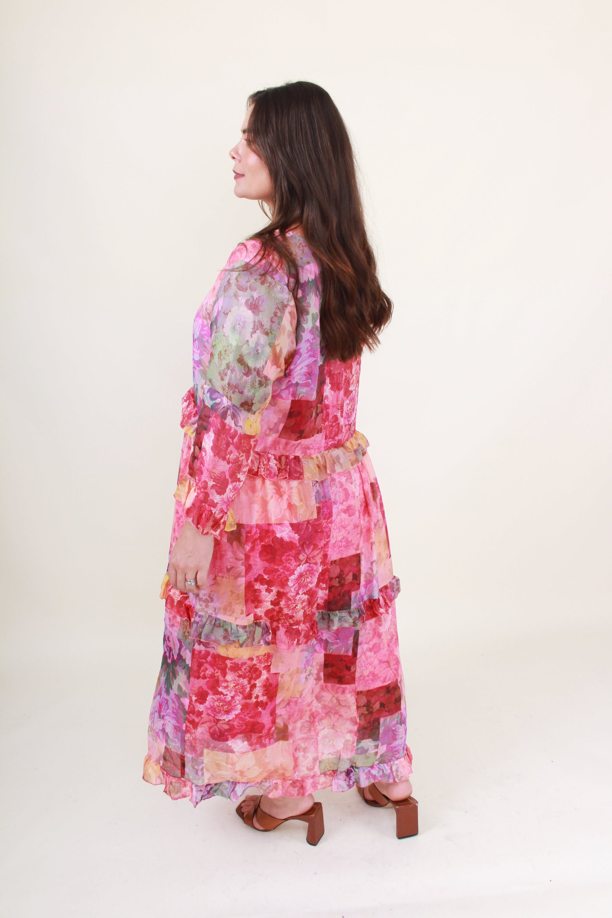 Woman wearing a colorful patchwork dress on a white background back side view