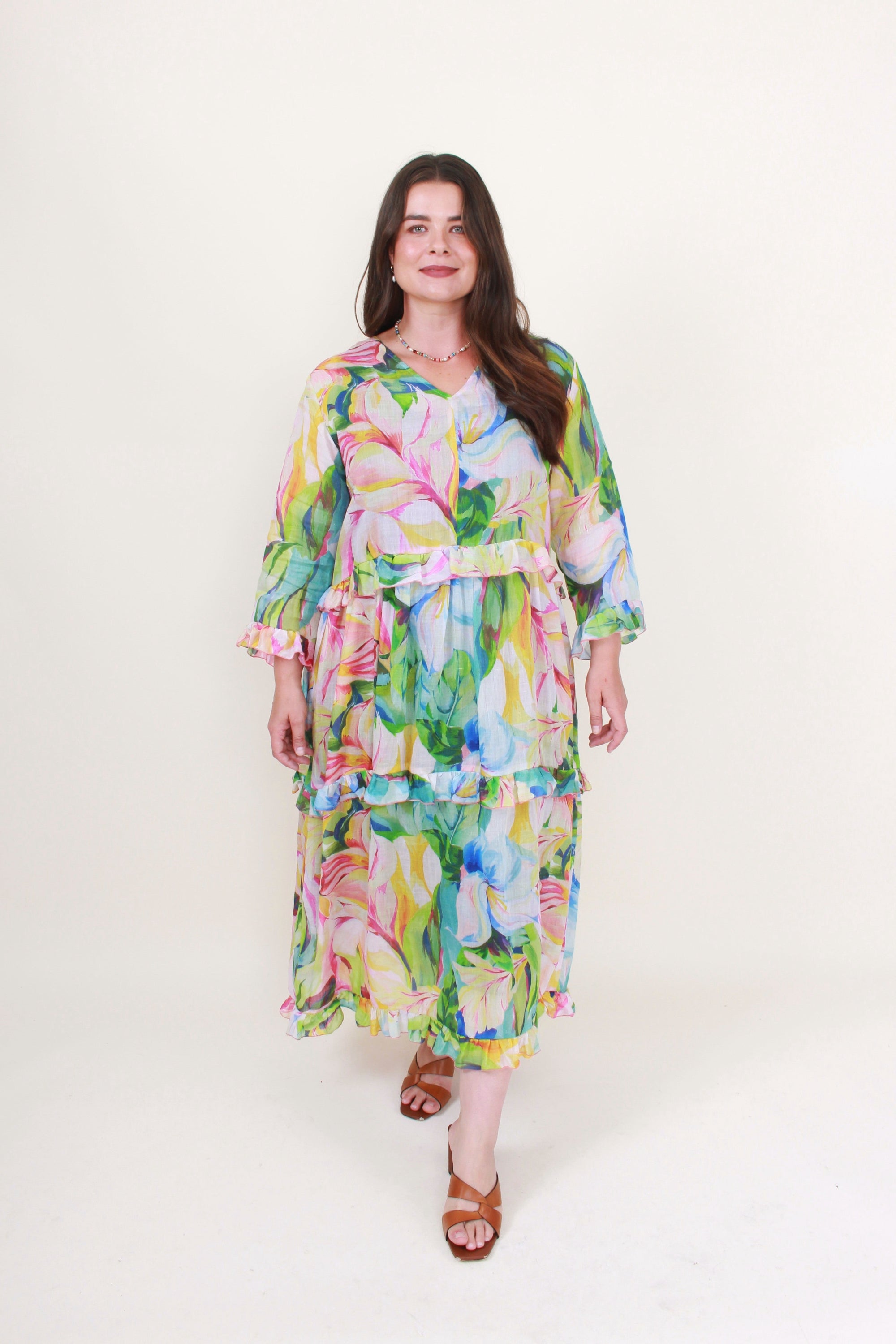 Woman wearing a colorful floral dress on a white background