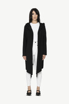 black longline jacket over white outfit worn by model 