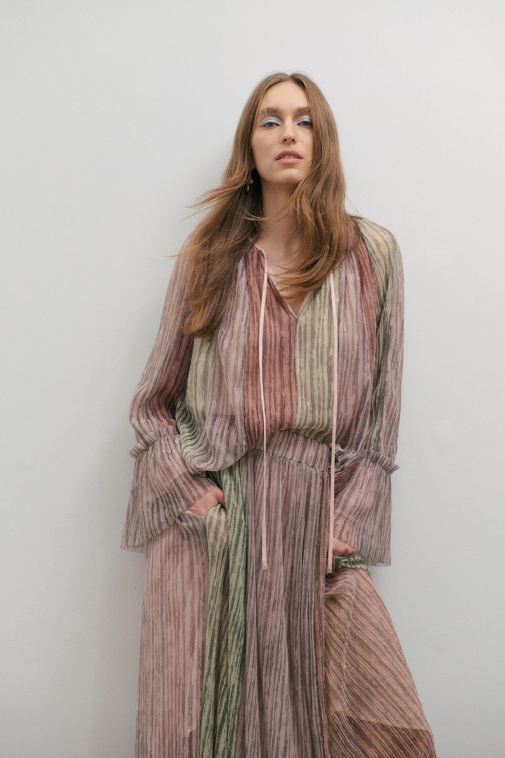 women wering a multicoloured shimmery blouse and skirt on a white backdrop