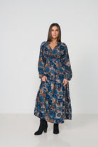 Woman wearing a long floral dress on a white background