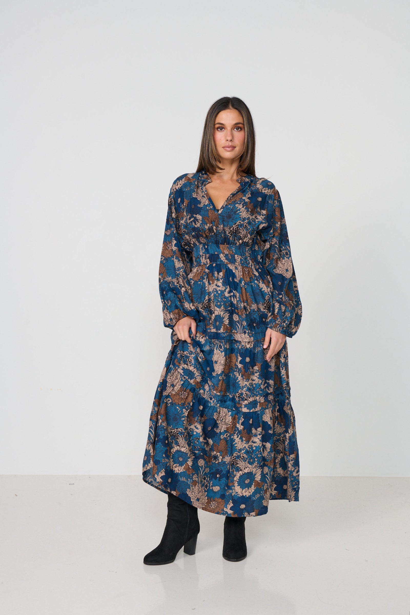 Woman wearing a long floral dress on a white background