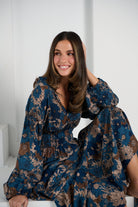 Woman wearing a blue floral dress against a white background