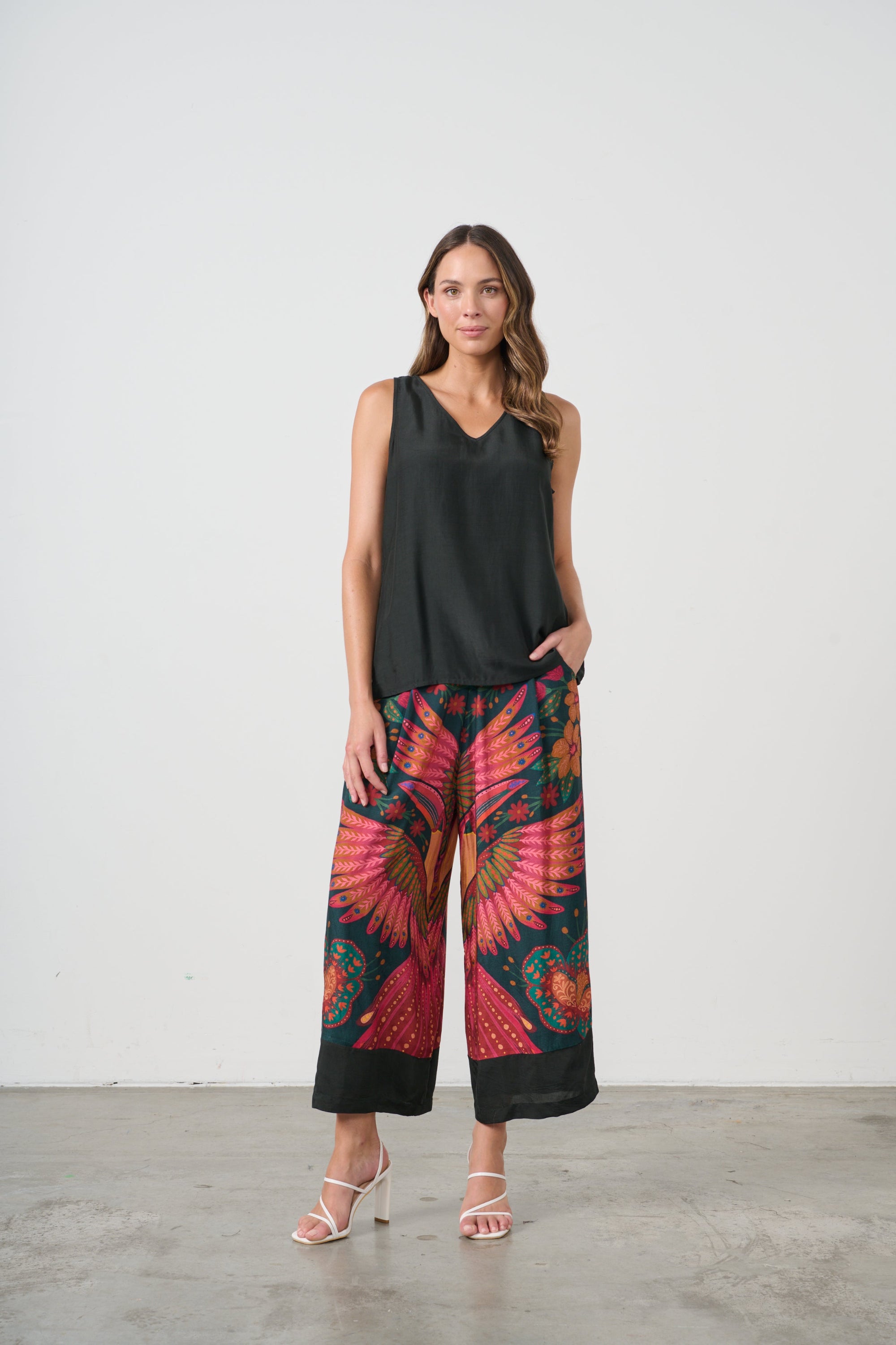 womens wide leg pant with multi toucan print and black top worn by model 