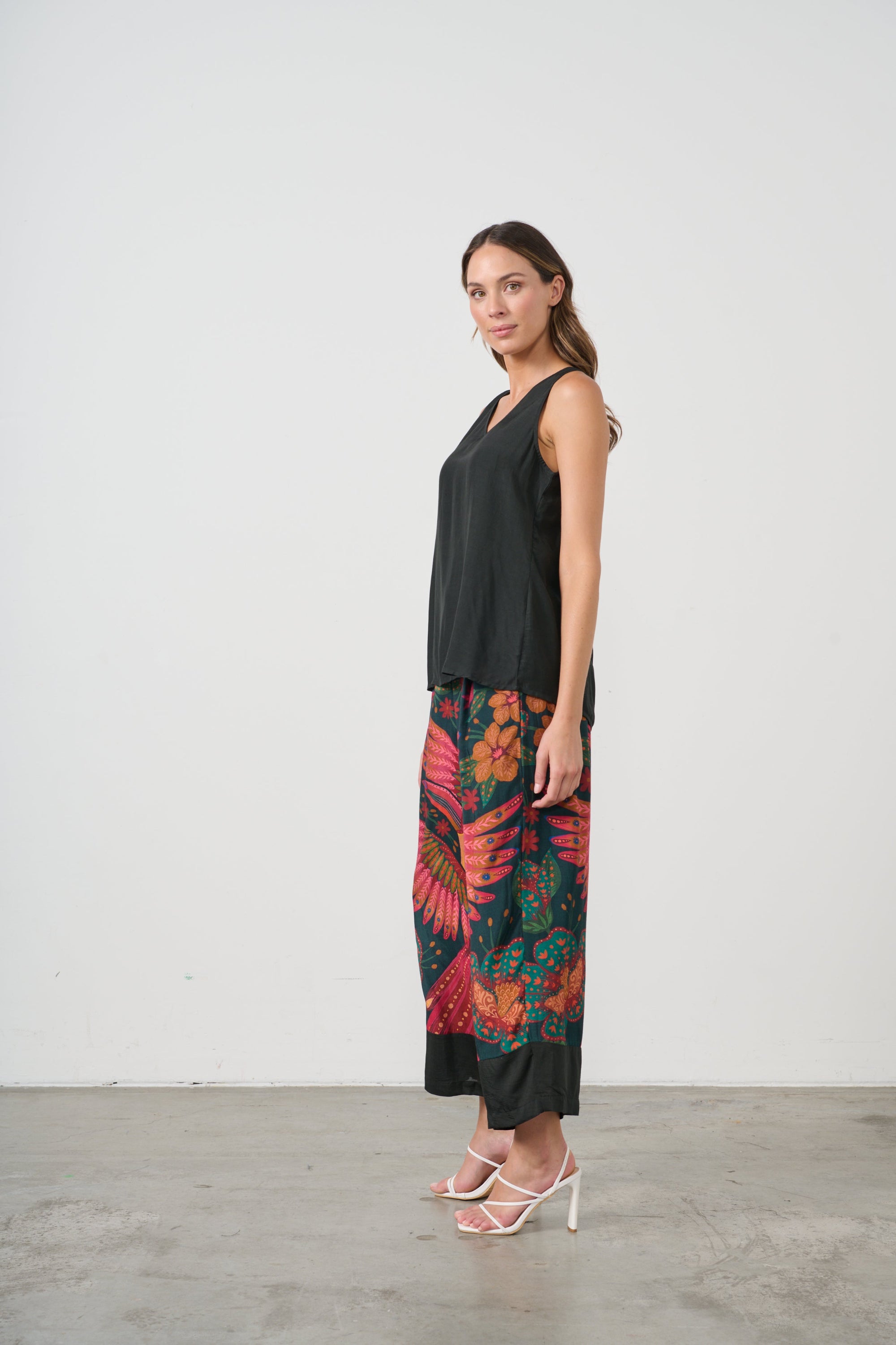 womens wide leg pant with multi toucan print and black top worn by model side view