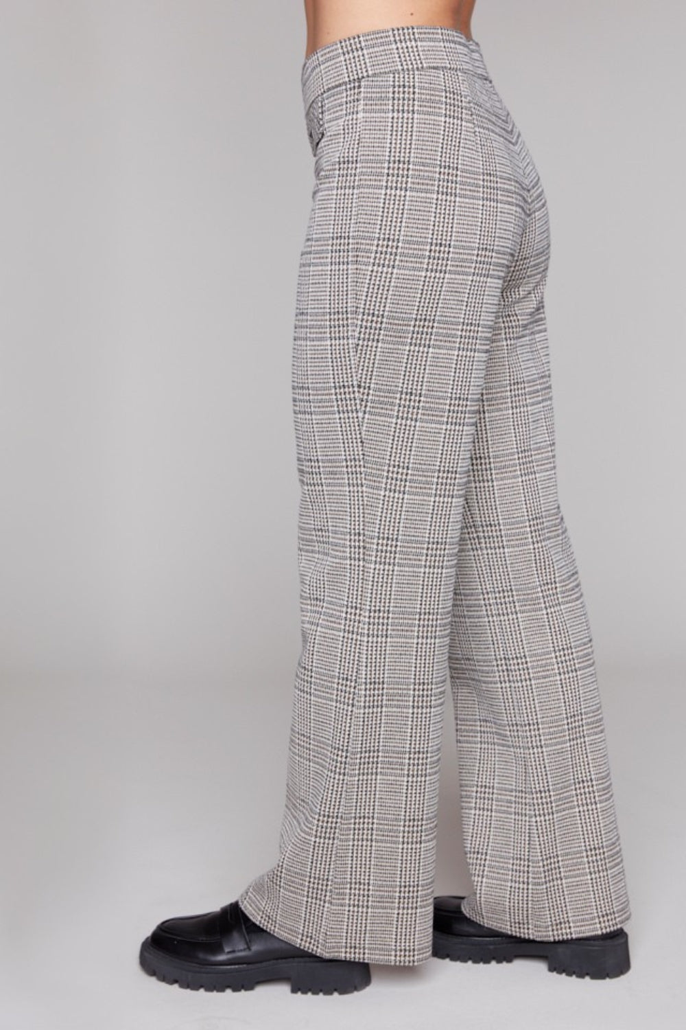 Plaid pants worn by a person on a plain grey background side angle