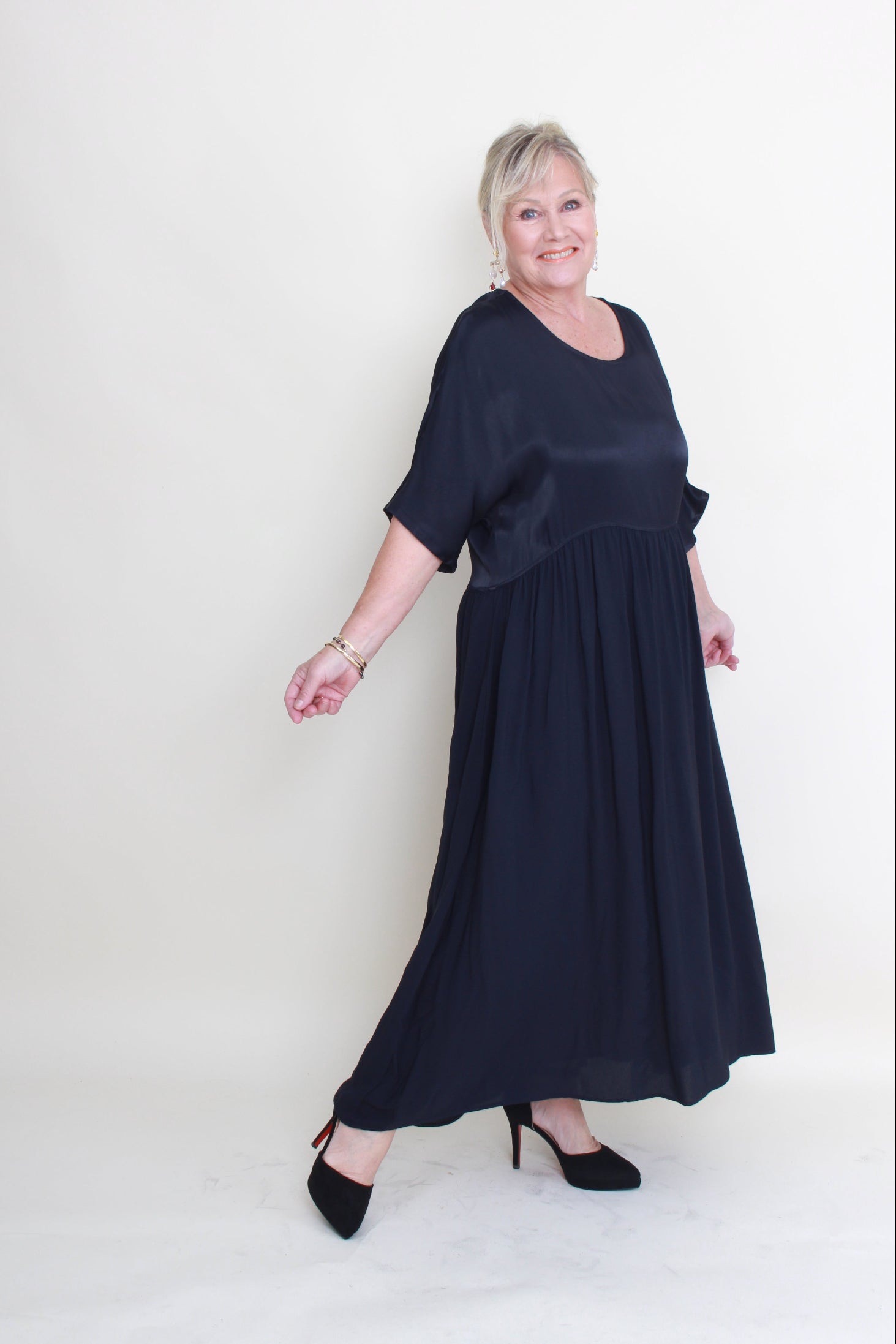 Woman wearing a long dark blue dress on a white background
