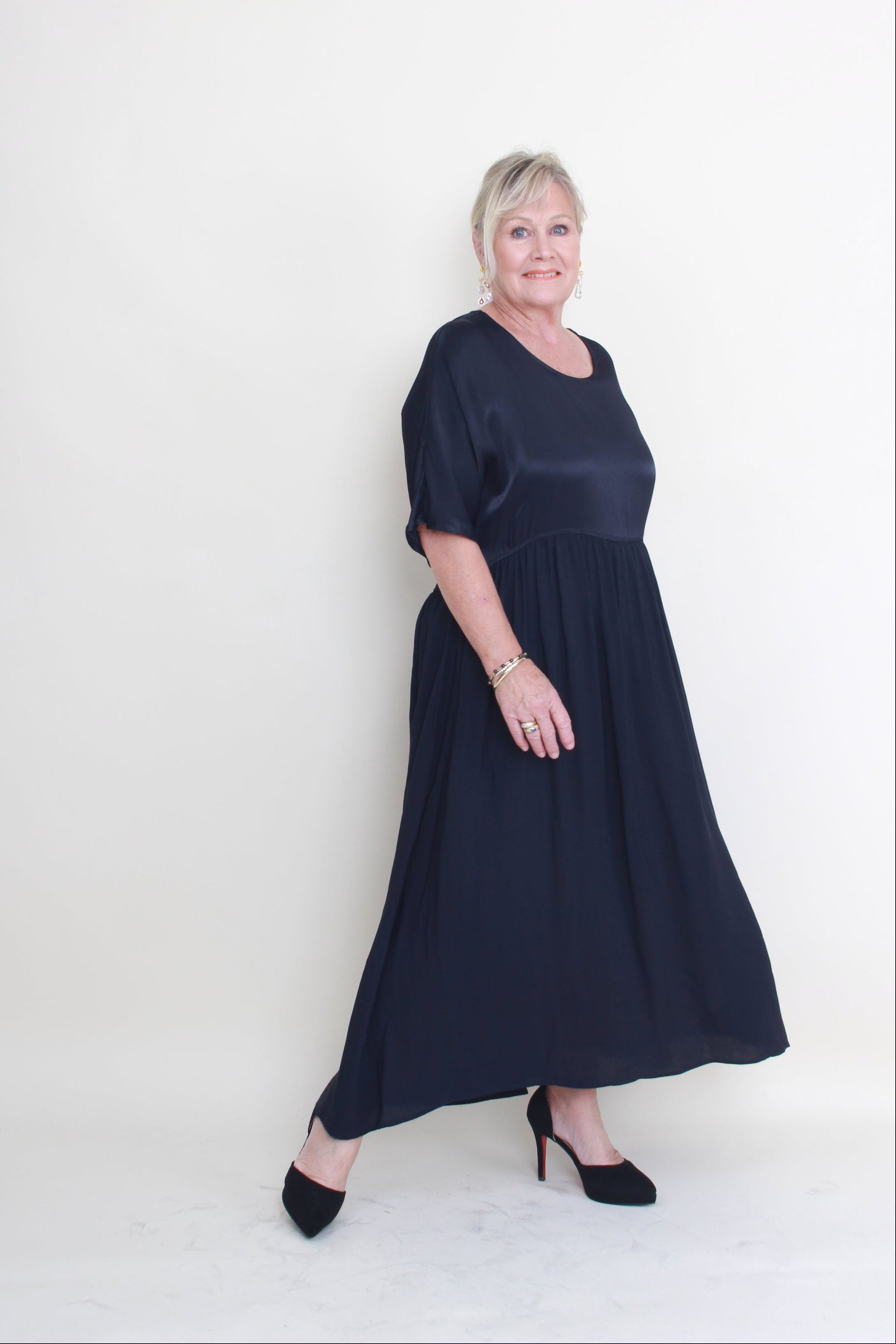Woman wearing a navy blue dress lying on a white background