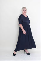 Woman wearing a navy blue dress lying on a white background