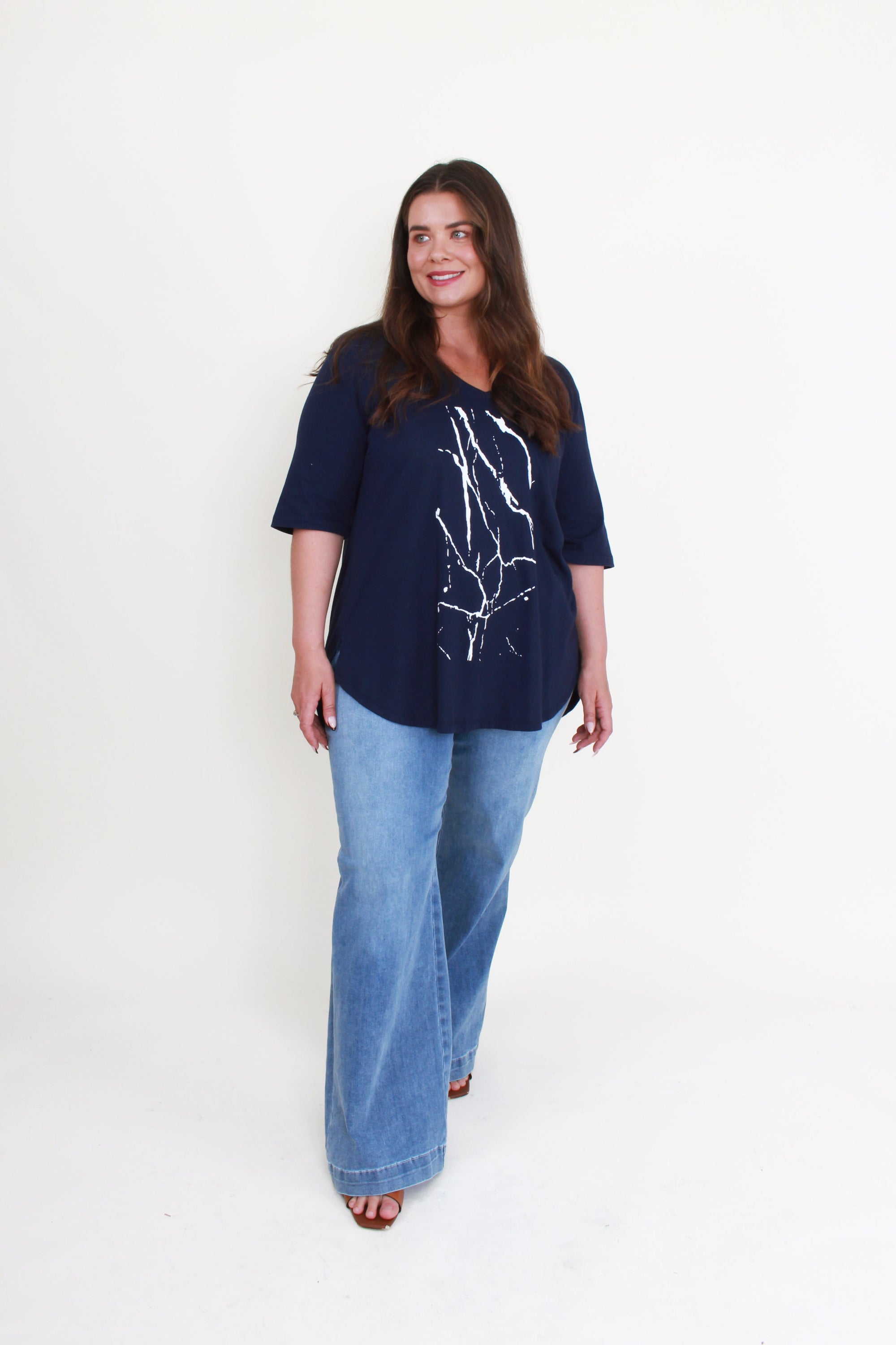 navy tee with white graphic and jeans worn by model 