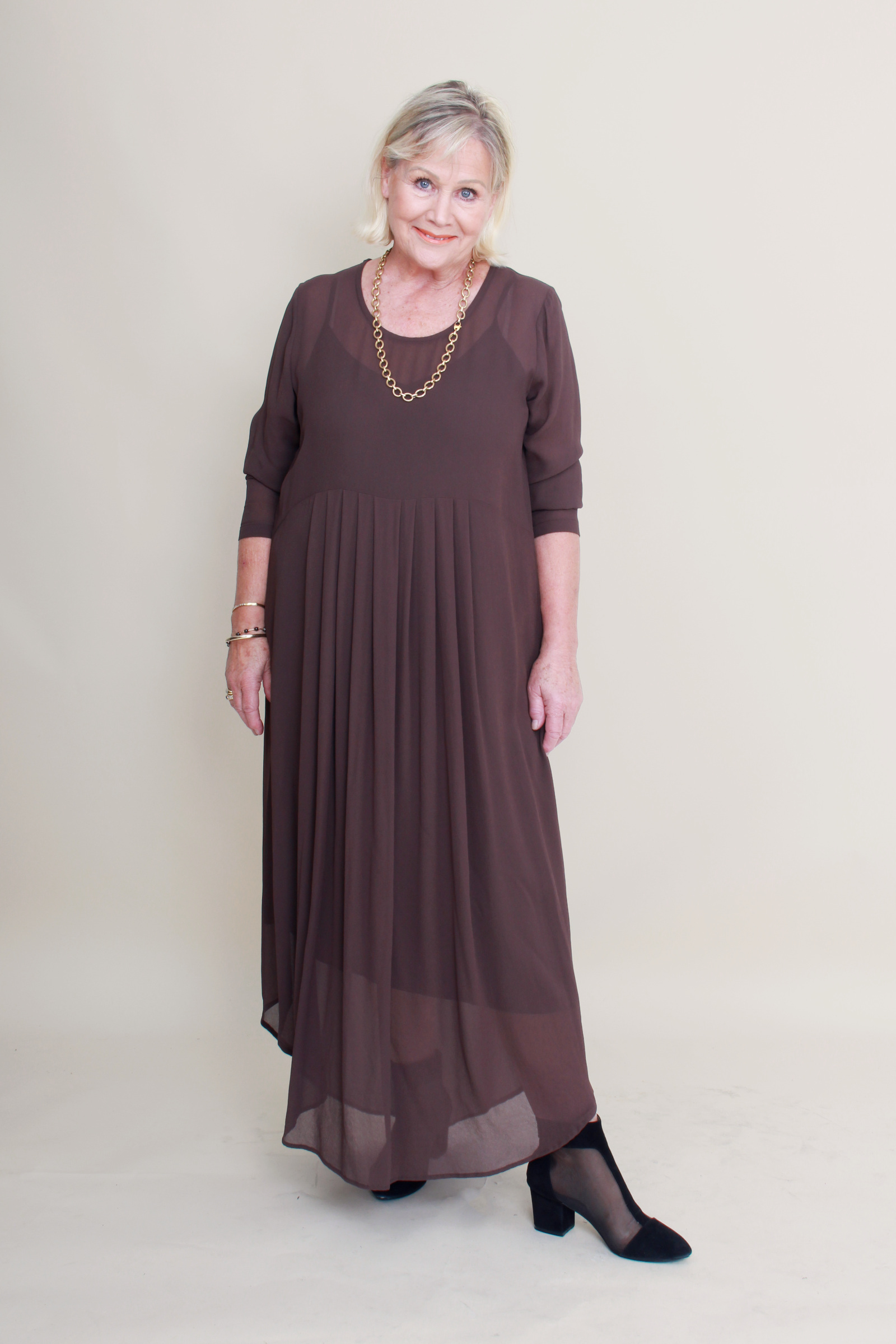 Woman wearing a brown dress with a plain background