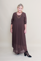 Woman wearing a brown dress with a plain background