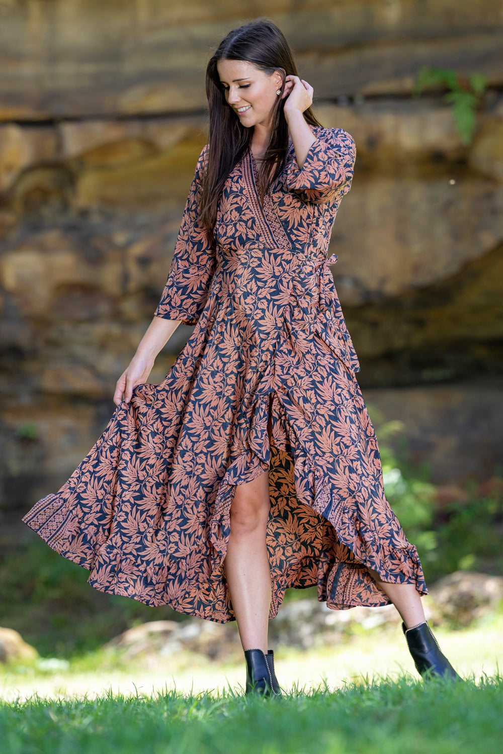midi wrap dress in rust and navy worn by model grassy background