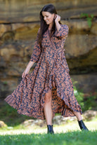 midi wrap dress in rust and navy worn by model grassy background