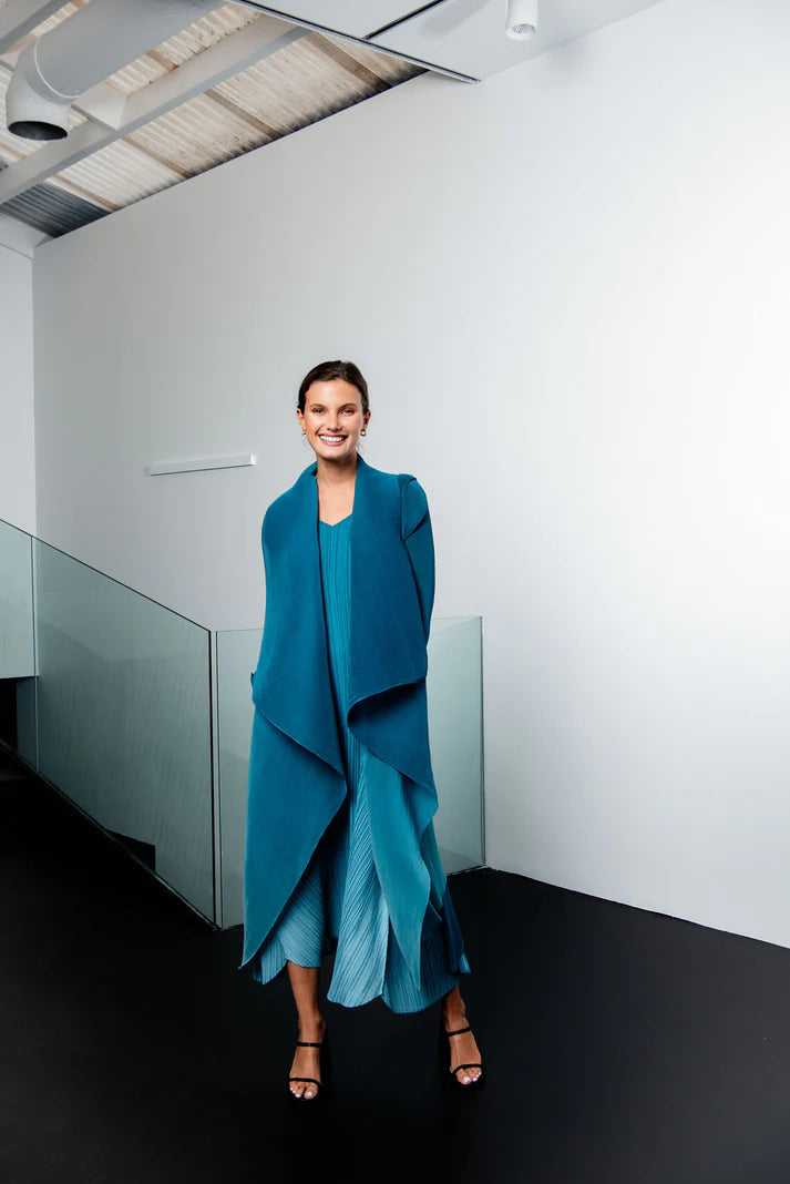 Woman in a blue dress standing in a modern indoor setting