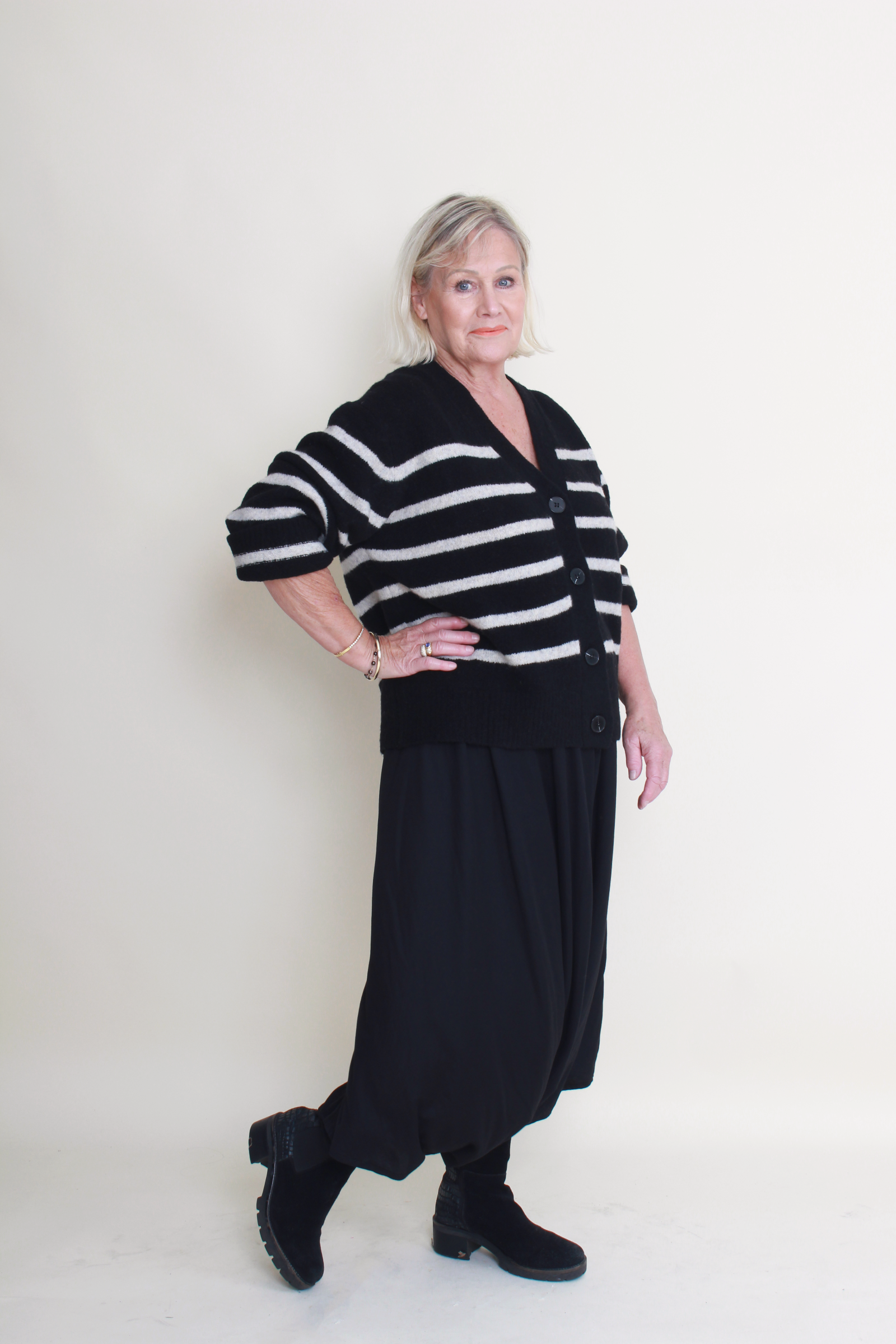 Woman wearing a black and white striped sweater with a plain background