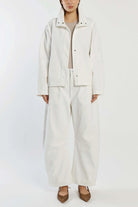 Person wearing a white outfit with a jacket and pants on a white background