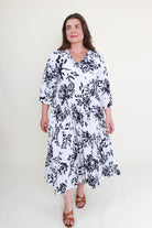 Woman wearing a black and white floral dress on a white background