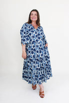 Woman wearing a blue floral dress on a white background