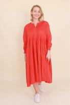 Woman wearing a red dress on a beige background