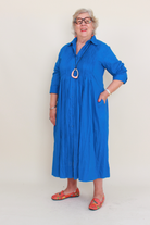 Woman wearing a blue dress with a plain background