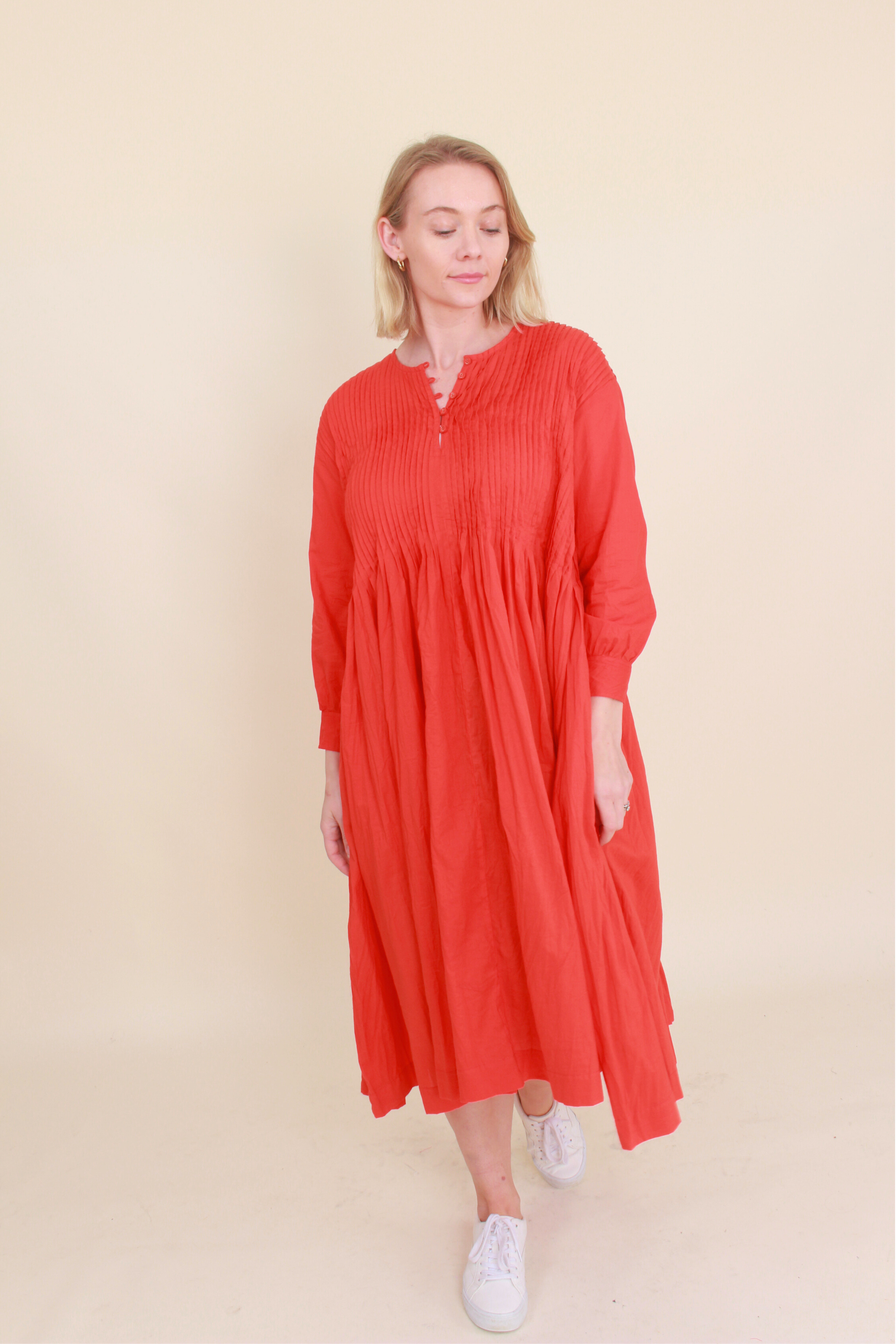 Woman wearing a red dress against a beige background
