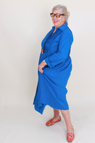Person wearing a blue dress with a plain background