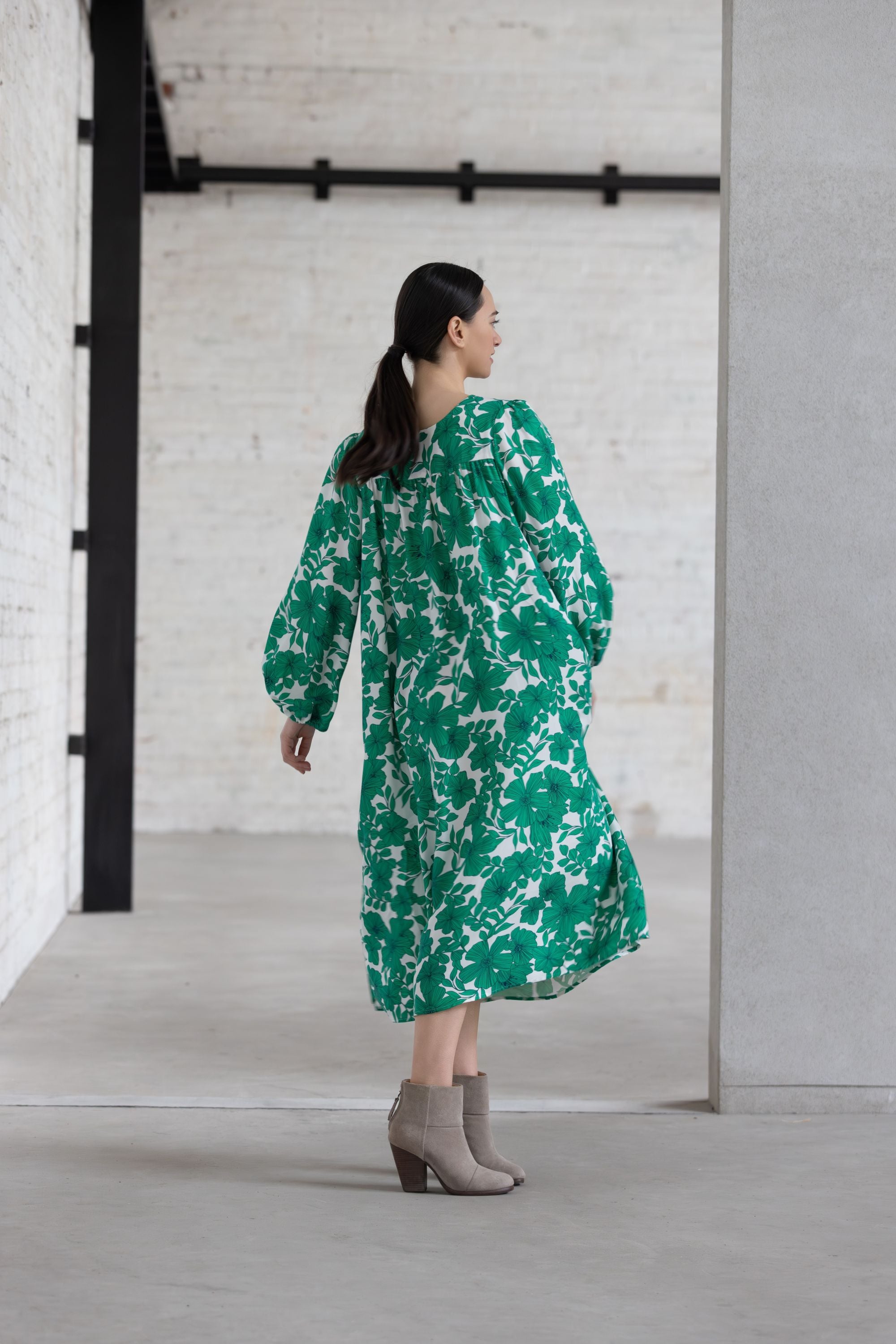 Woman wearing a green floral dress in an indoor setting