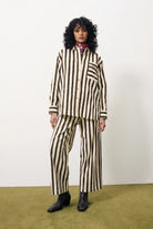 Person wearing a brown and white striped suit with a red scarf against a white background